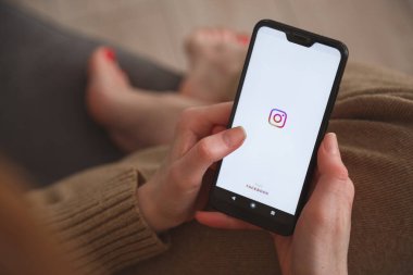 Minsk-Belarus: 27 Mayıs 2020: Instagram logosunun kadınların elinde olduğu akıllı telefondan görüntüyü kapat. Sosyal medya kavramı.