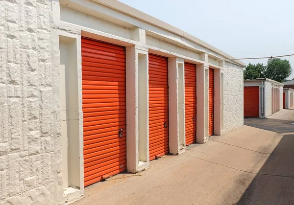 Fila de puertas metálicas naranjas de un almacén público Imagen de stock