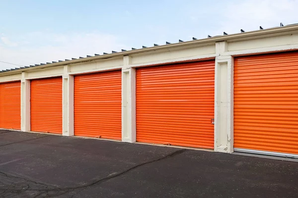 Fila de puertas metálicas naranjas de un almacén público Fotos de stock libres de derechos
