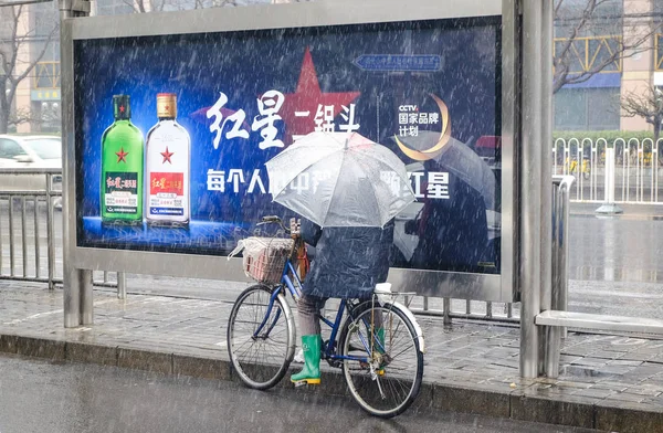 Una persona en una bicicleta sosteniendo un paraguas — Foto de Stock