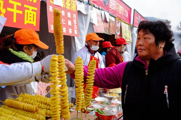Beijing, China - 7 de febrero de 2019: Espirales de papa en un palo. Festival de comida callejera en Beijing, China . — Foto de Stock