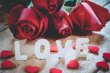 Resim yazısı kelime aşk, kalp ve ahşap üzerinde kırmızı gül 