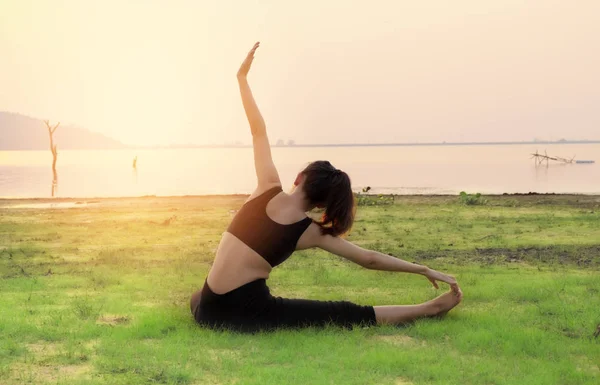 A mulher Yoga é relaxar com belo pôr do sol de fundo no — Fotografia de Stock