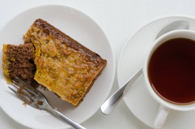 Bir fincan çay ile karamel fıstık tepesinde Brownie kek.