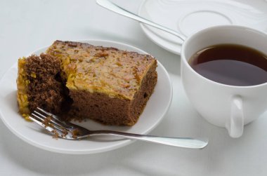 Bir fincan çay ile karamel fıstık tepesinde Brownie kek.