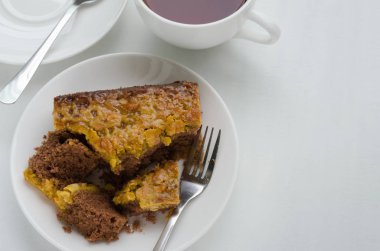 Bir fincan çay ile karamel fıstık tepesinde Brownie kek.