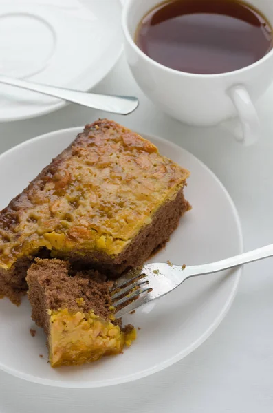 Caramel Peanut-Topped Brownie Cake with A Cup of Tea. — Stock Photo, Image