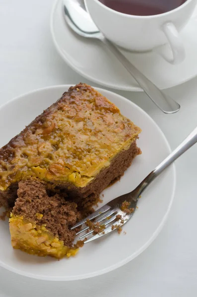 Caramel Peanut-Topped Brownie Cake with A Cup of Tea. — Stock Photo, Image