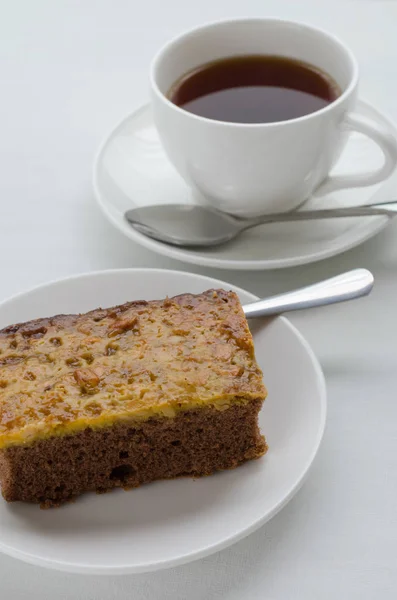 Torta Brownie al caramello e arachidi con una tazza di tè . — Foto Stock