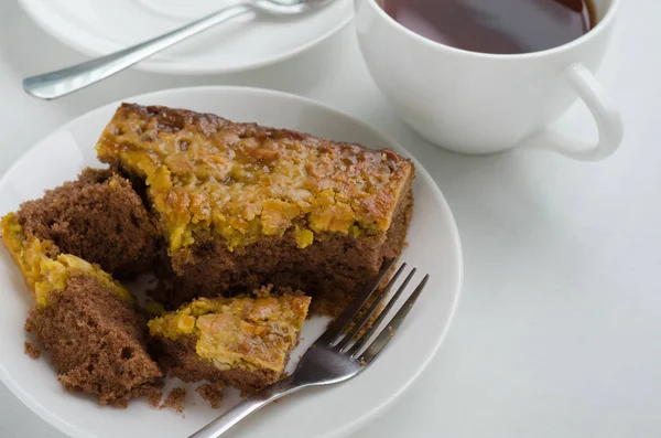 Caramel Peanut-Topped Brownie Cake with A Cup of Tea. — Stock Photo, Image