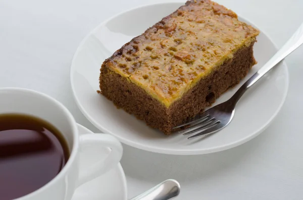 Torta Brownie al caramello e arachidi con una tazza di tè . — Foto Stock