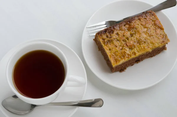 Torta Brownie al caramello e arachidi con una tazza di tè . — Foto Stock