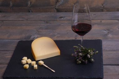 cheese and wine lie on a stone 