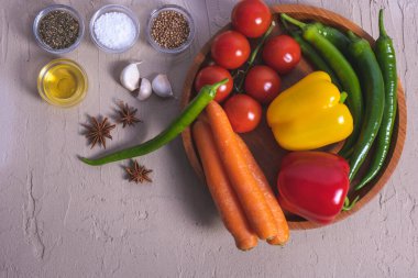 Havuç, baharat, paprika, domates tahta tepside yatıyor. 