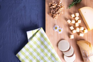 on a wooden board bread rolls, sliced cheese with berries 