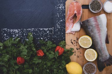 Tuz, yeşillik, limon, baharat ve somon dilimleri ağaçta.