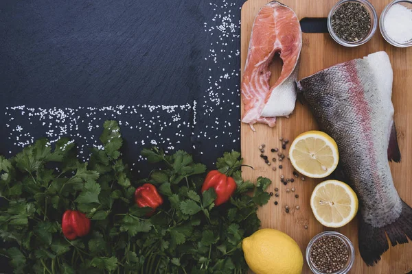 Tuz, yeşillik, limon, baharat ve somon dilimleri ağaçta.