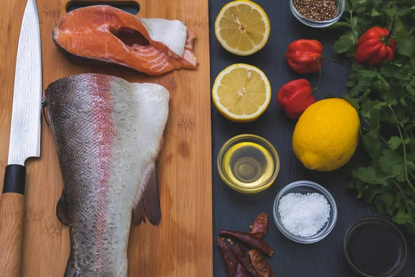 Knife and chopped salmon on the table, next to which are various — Stock Photo, Image