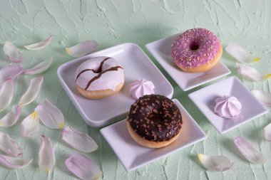sweet donuts on white dishes on a table