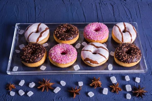 pieces of sugar and delicious donuts lie on a glass tray