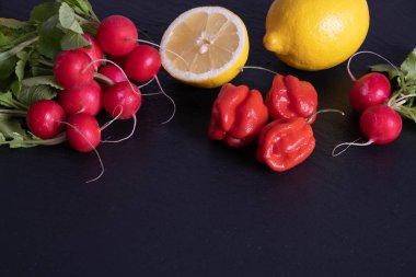 limon, biber ve kırmızı turp bir masada yatıyor.