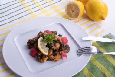 Masada limon ve karides tabağında beyaz bir arka planda