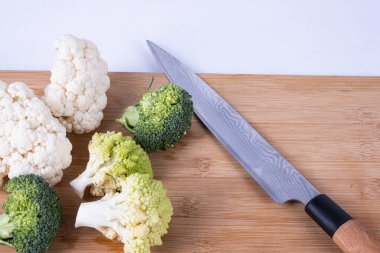 Yıkanmış brokoli ve karnabahar beyaz arka planda bir masada.