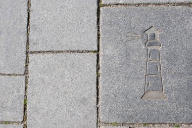Avrupa 'nın eski liman şehrinde, ilkbaharda, taş kaldırımda bir deniz feneri çizimi