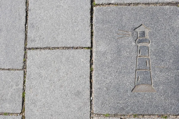 drawing of a lighthouse on a stone sidewalk in the old European port city, in spring
