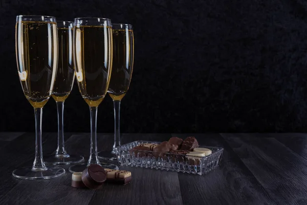 テーブルの上のシャンパンとチョコレートでいっぱいになったグラスは — ストック写真