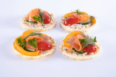 somon, domates, kırmızı biber ve dereotlu mısır gözlemesi beyaz arka planda.