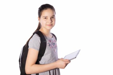 Liseli kız elinde bir tablet tutuyor ve beyaz bir arka plana bakıyor.