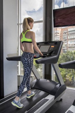 spor salonunda genç kadın giriyor