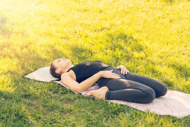 Beyaz bir kadın parkta yoga yapıyor..