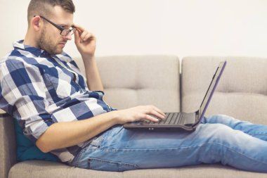 bir dizüstü bilgisayar ile gözlüklü adam