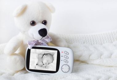 Bebek telsizi hafif bir arka plan üzerinde bir oyuncak ayı çevrili bebeğin güvenliği için. yakın çekim