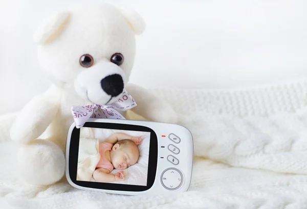 Babyfoon voor veiligheid van de baby omgeven door een teddybeer op een lichte achtergrond. Close-up — Stockfoto