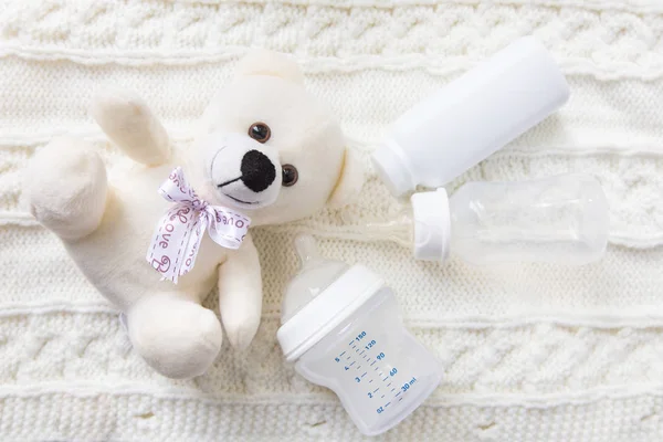 Αξεσουάρ για το μωρό. Ένα μπουκάλι γάλα και μία αρκούδα παιχνίδι — Φωτογραφία Αρχείου