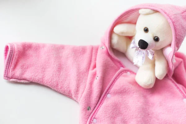 Accessoires voor de pasgeborene. Teddybeer verpakt in babykleding — Stockfoto