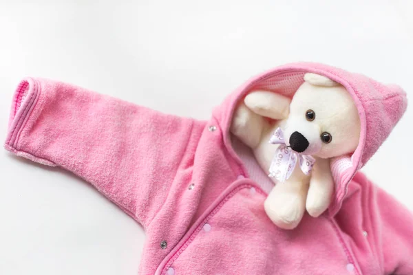 Accessoires voor de pasgeborene. Teddybeer verpakt in babykleding — Stockfoto
