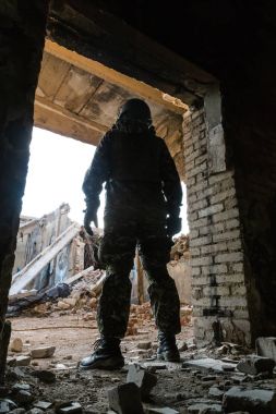 Yıkık bina koridorda duran bir askerin siluet