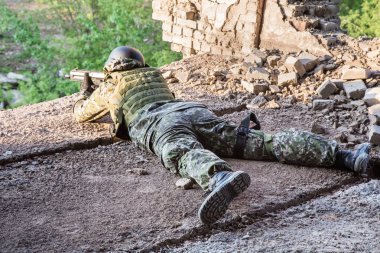 Asker savaş konumu hedeflemektedir. Askeri eylemler tahrip binalar arasında. Saldırı ve savunma