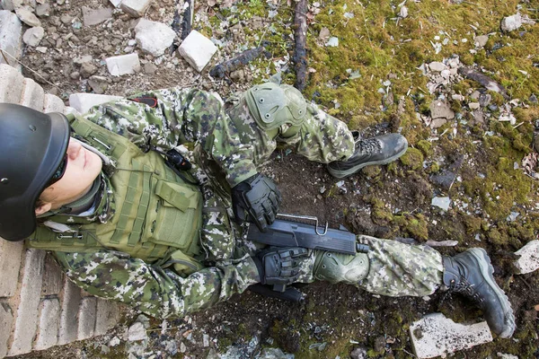 De soldaat zit leunend tegen een muur in een verwoeste gebouw. Militaire conflicten — Stockfoto