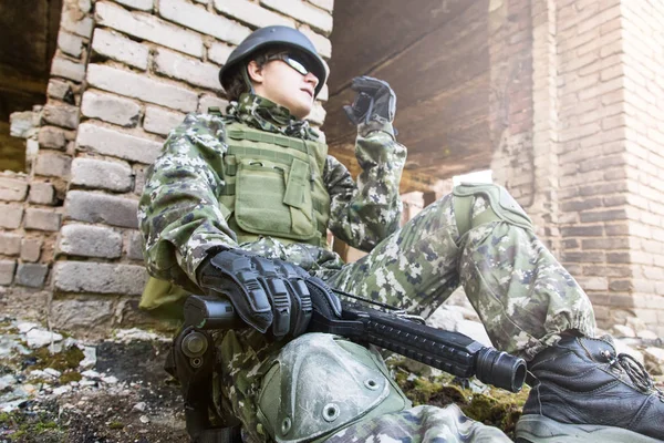 De soldaat gesprekken op de radio zit in een verwoeste gebouw. Militaire conflicten en communicatie — Stockfoto