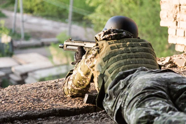 Voják se zaměřuje z bojové pozice. Vojenské akce mezi zničených budov. Útok a obrana — Stock fotografie