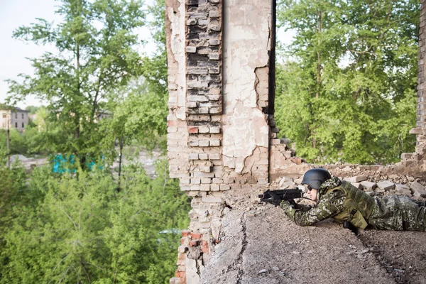 Voják se zaměřuje z bojové pozice. Vojenské akce mezi zničených budov. Útok a obrana — Stock fotografie