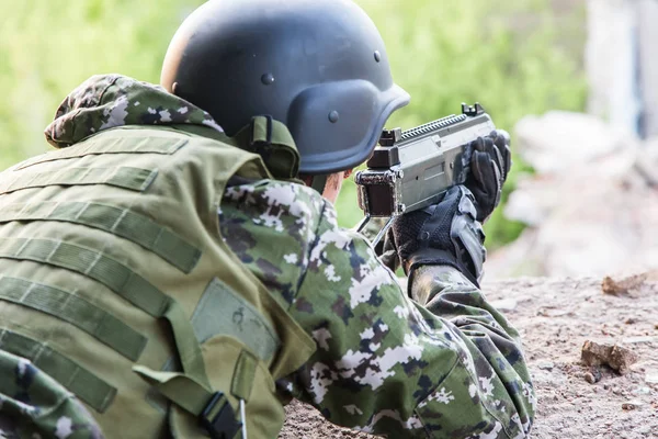 Військовослужбовець націлений на бойове положення. Військові дії серед зруйнованих будівель. Напад і оборона — стокове фото