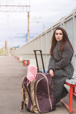 Bir boş tren istasyonu bir çanta ile kız. Tren bekliyor