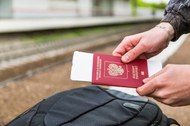 Bir sırt çantası arka plan üzerinde bir pasaport biletleri ile holding eller
