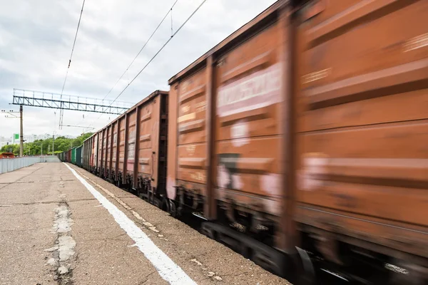 El tren de mercancías en movimiento está pasando por la estación. Ferrocarriles rusos — Foto de Stock